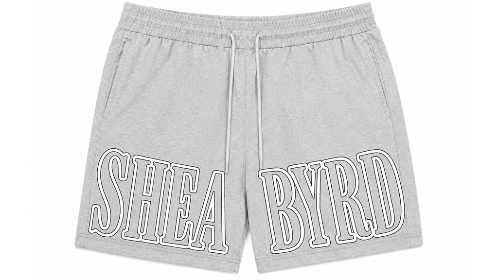 Light gray heather sweat shorts with a white drawstring and large white outlined 'SHEA BYRD' text across the front, shown on a plain white background.